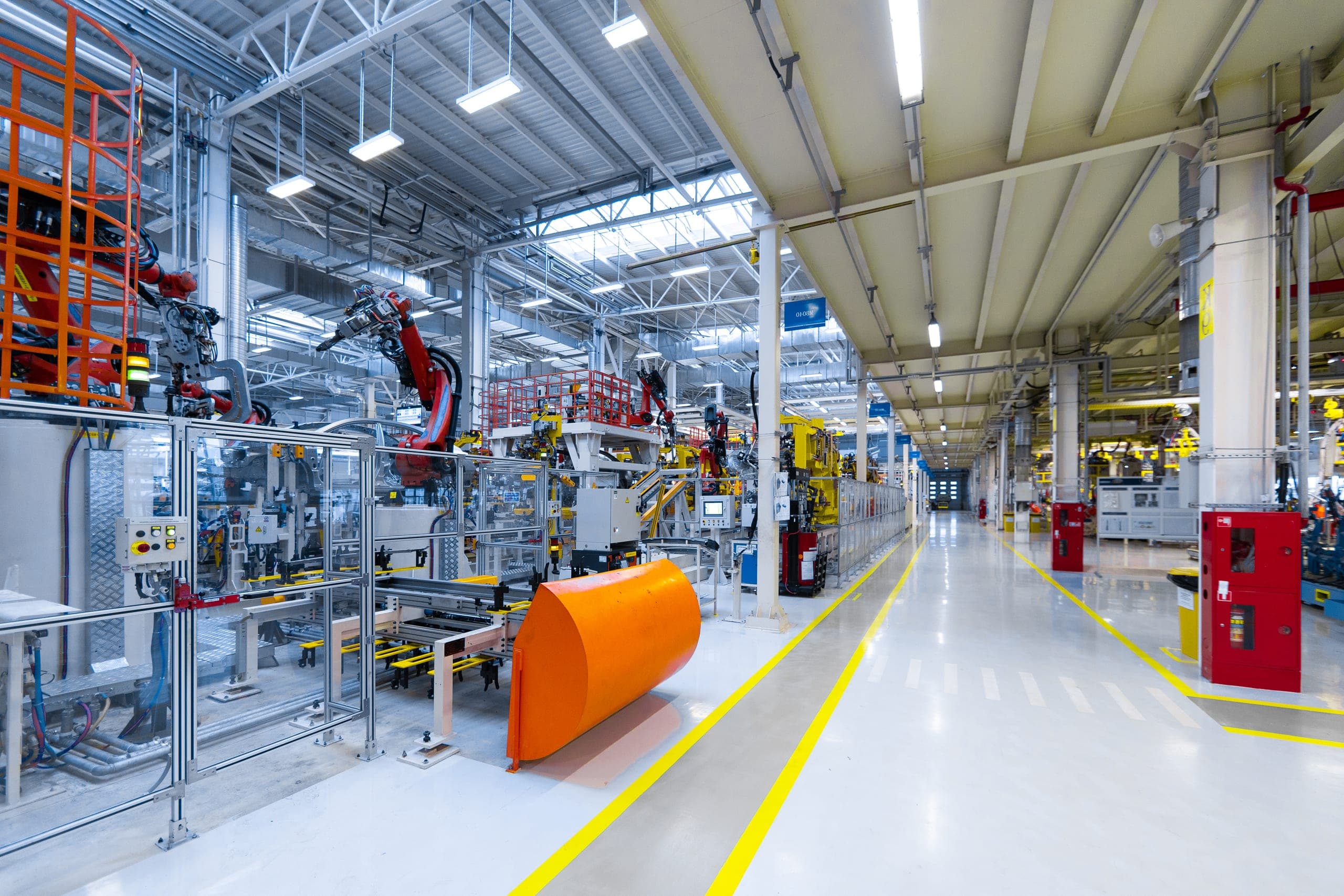 Robotic arms along an automotive assembly line on a factory floor.